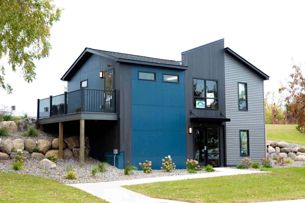 modern styled building built into a grassy hill featuring a deck and landscaped yard
